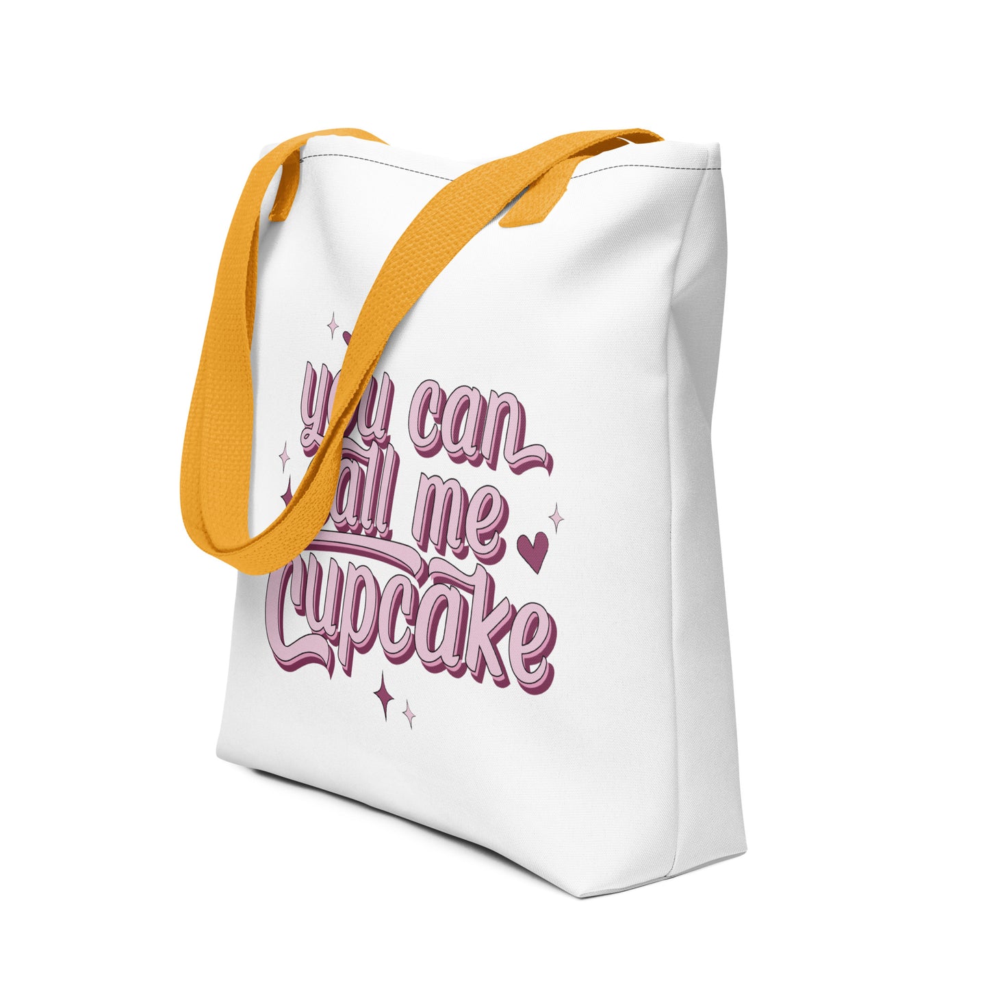 a white tote bag with a yellow strap that reads You Can Call Me Cupcake in large pink lettering