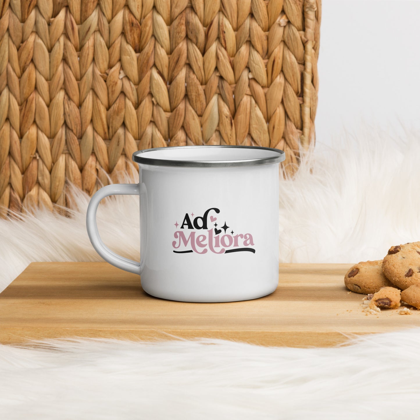 An enamel mug that reads Ad Meliora, in black and gold lettering