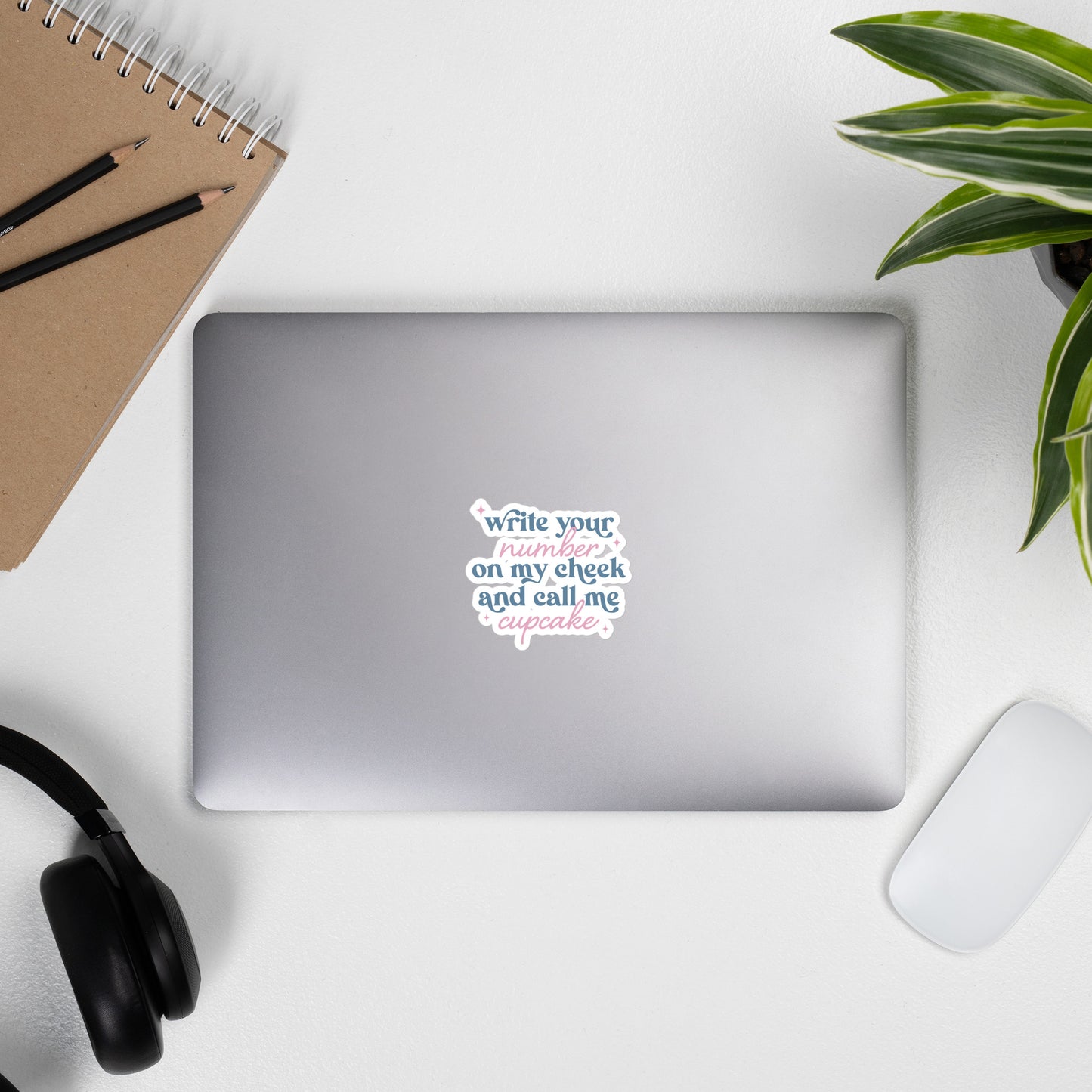 A sticker with blue and pink text, a combination of print and cursive that reads "Write Your Number on my cheek and call me cupcake". The sticker is 4 x 4 inches