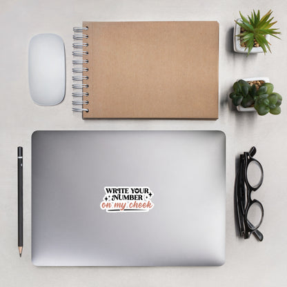 a sticker that reads "Write Your Number On My Cheek" with black lettering for "write your number" and "on my cheek" in pink cursive. The sticker is 4 x 4 inches