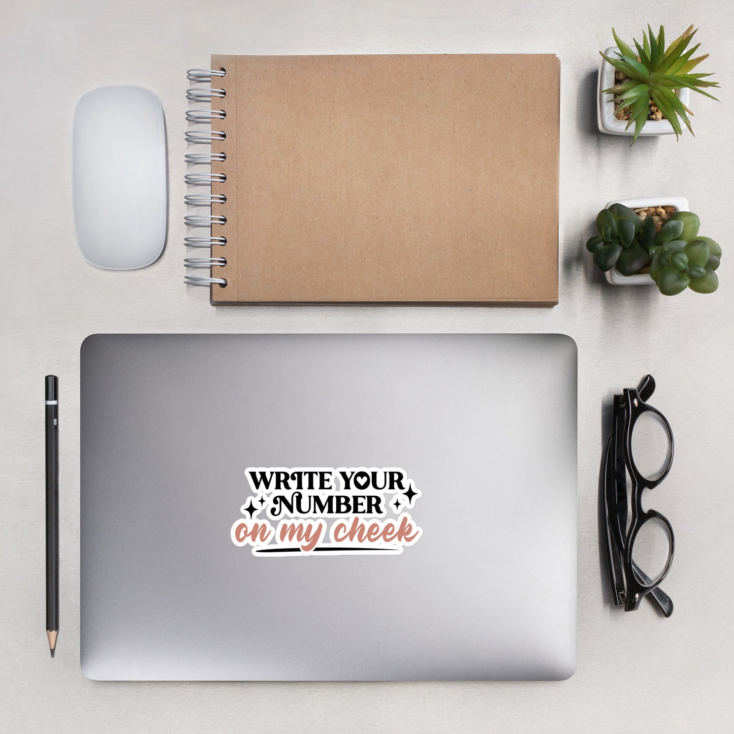a sticker that reads "Write Your Number On My Cheek" with black lettering for "write your number" and "on my cheek" in pink cursive. The sticker is 5.5 x 5.5 inches
