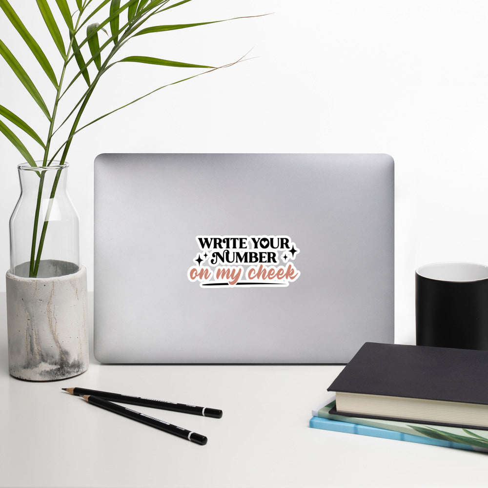 a sticker that reads "Write Your Number On My Cheek" with black lettering for "write your number" and "on my cheek" in pink cursive. The sticker is 5.5 x 5.5 inches