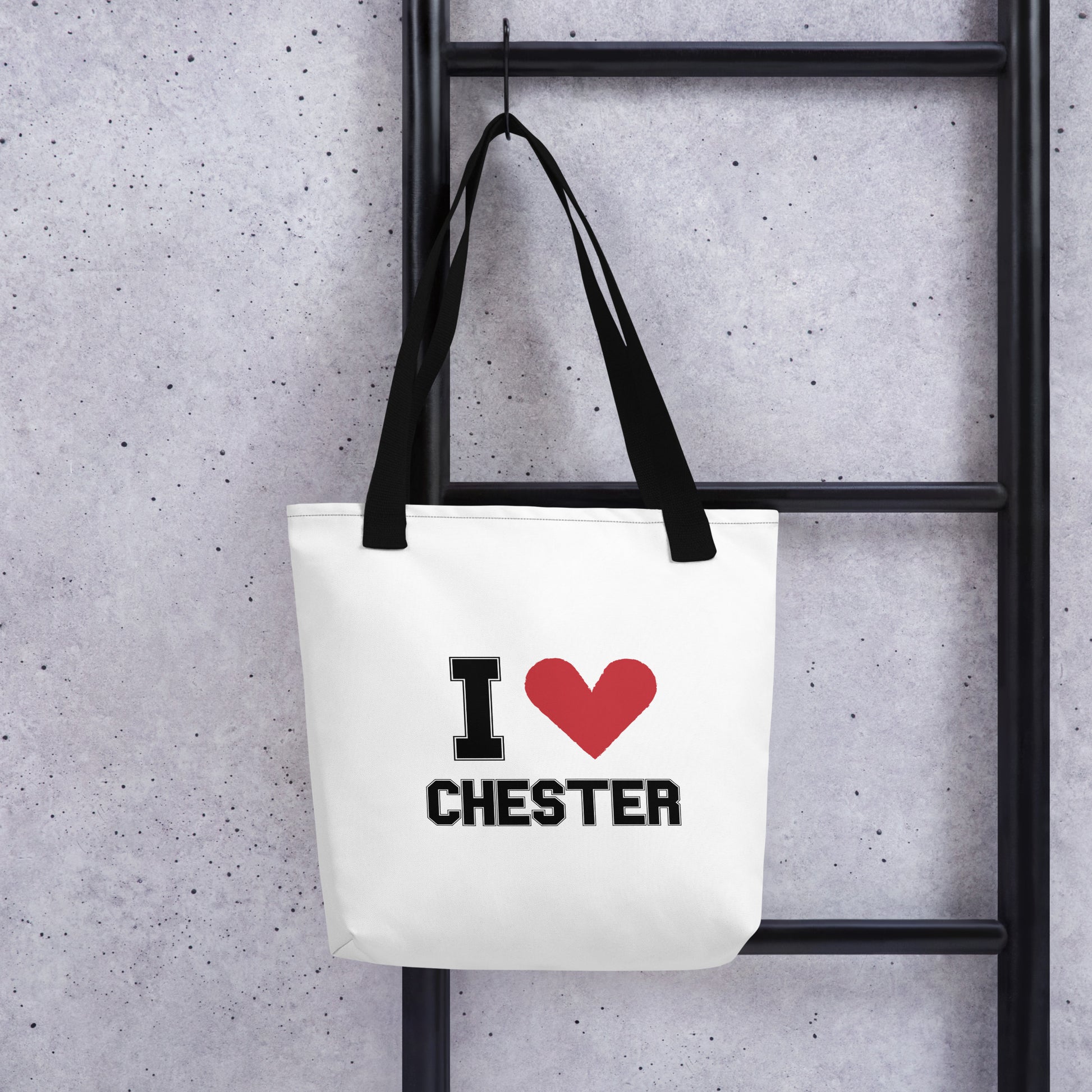 a black-strapped white tote bag that reads I Heart Chester