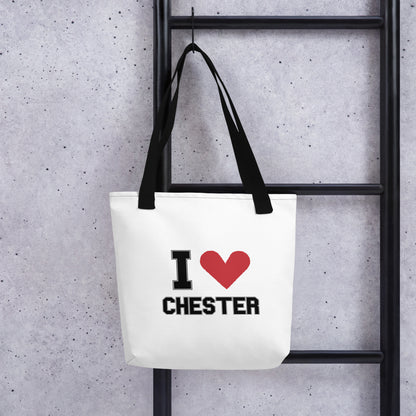 a black-strapped white tote bag that reads I Heart Chester