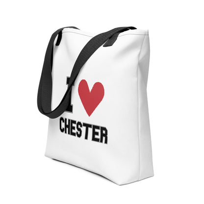 a black-strapped white tote bag that reads I Heart Chester