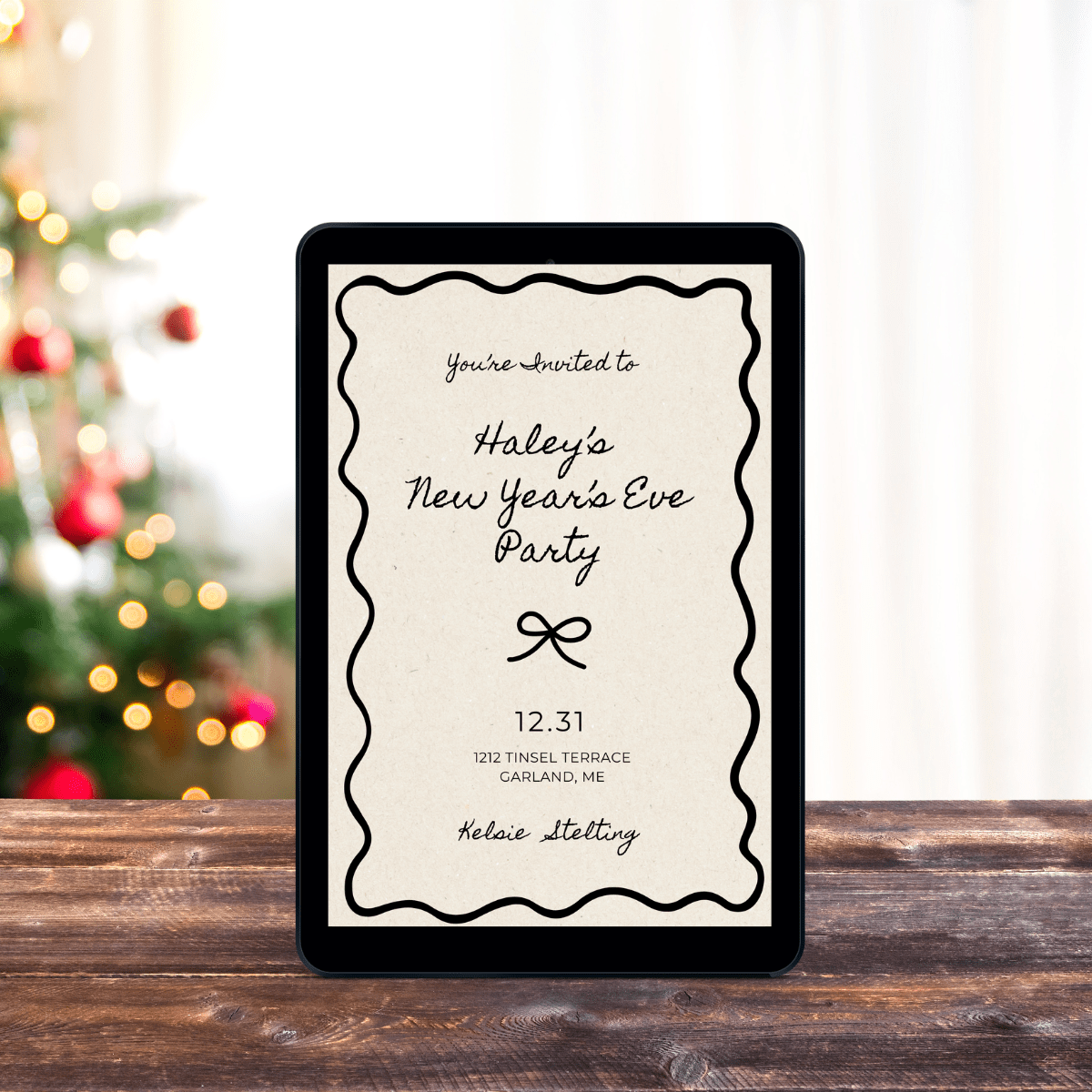 An ebook cover shows a party invitation that reads "You're Invited to Haley's New Years Eve Party, 12.31, 1712 Tensil Terrace Garland ME
Kelsie Stelting" the ebook sits on a table with a christmas tree in the background
