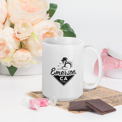 A white mug with the Emerson, CA logo. Preeminently featuring a beach, a palm tree and the sun