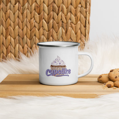 a white enamel mug with a large cupcake logo. The cupcake logo is a large cupcake covered in sprinkles, with cupcake written over it in pink block letters 