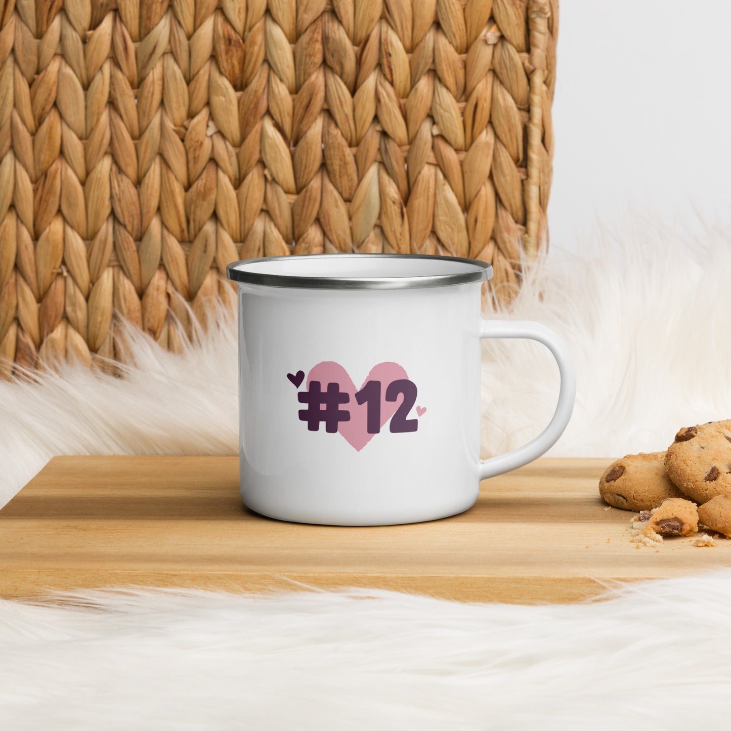 a white enamel mug with the I Heart #12 Logo. The Number 12 Logo is a large pink heart with #12 in black written over the heart. 