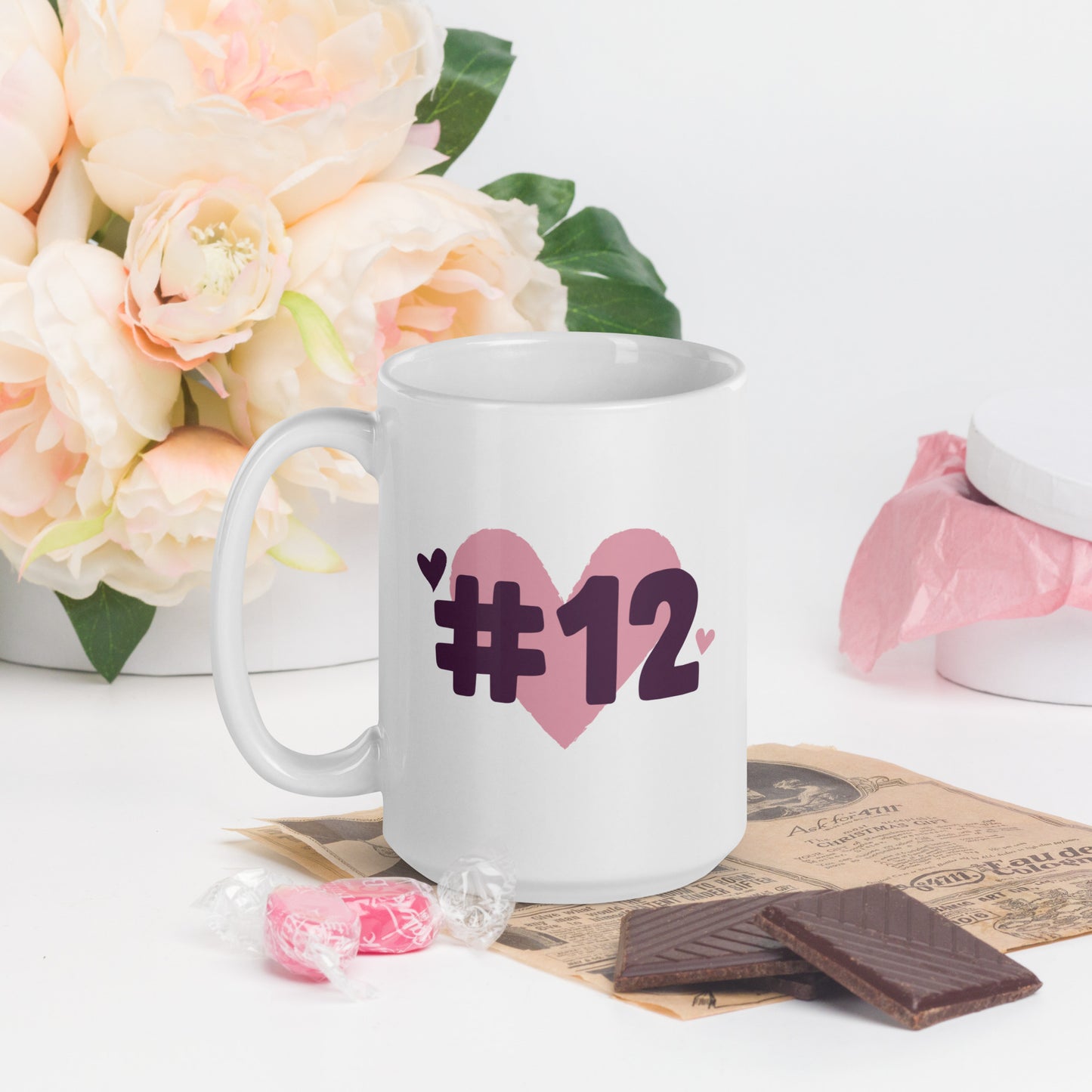 A white coffee mug with a logo of a heart under #12 in black text