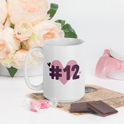 A white coffee mug with a logo of a heart under #12 in black text