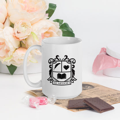 A white mug with a coat of arms logo. The coat of arms features an open book, a quill, a heart, and the words Ad Meliora below