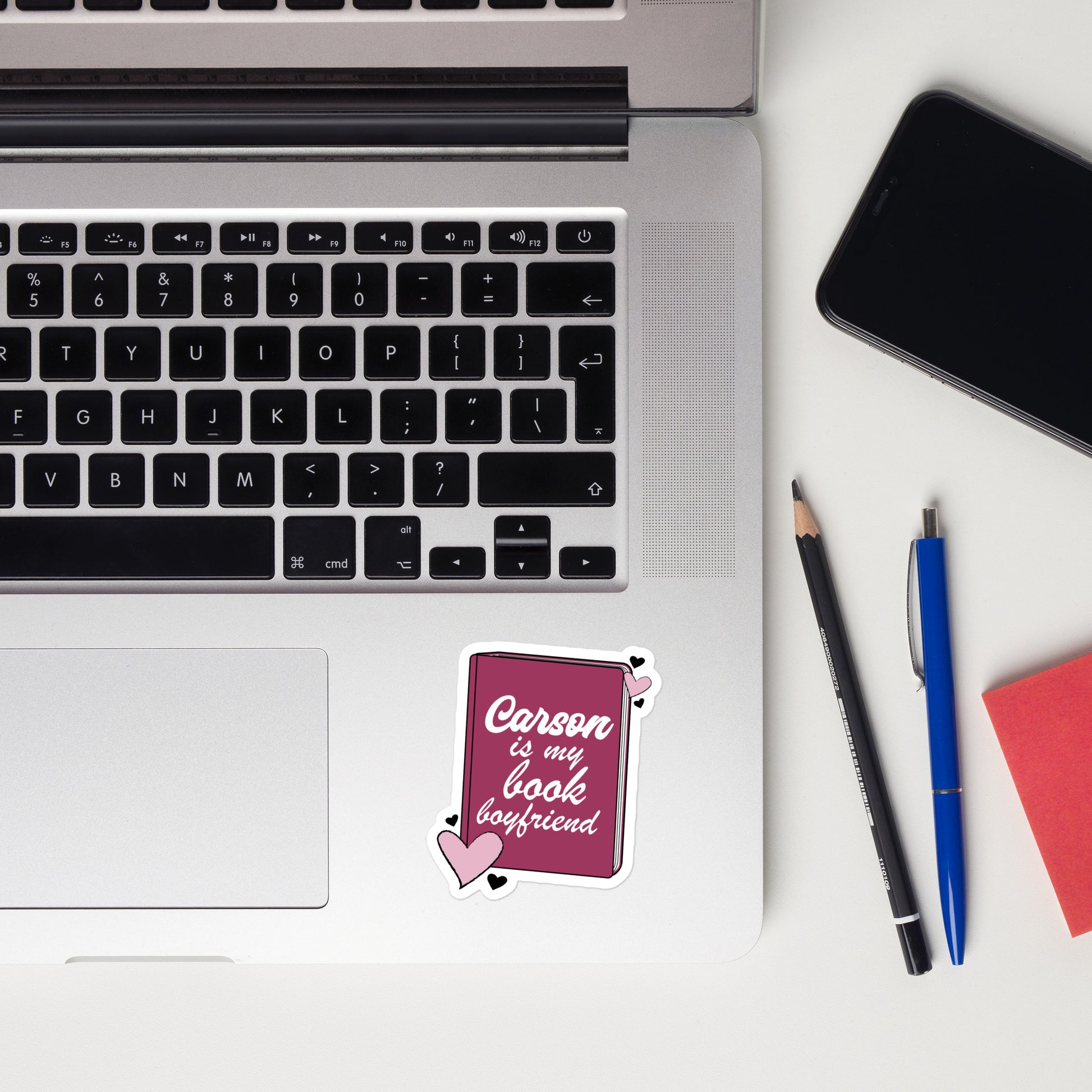 a sticker with the Carson logo. The Carson  Logo is a deep purple book with the words Beckett is my book Boyfriend in cursive, with hearts around the book. 