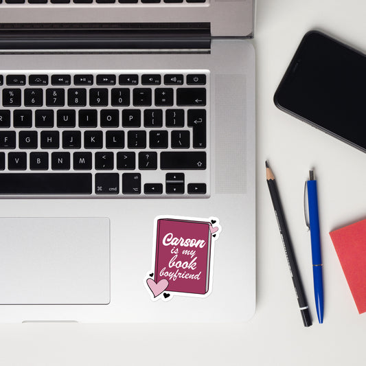 a sticker with the Carson logo. The Carson  Logo is a deep purple book with the words Beckett is my book Boyfriend in cursive, with hearts around the book. 