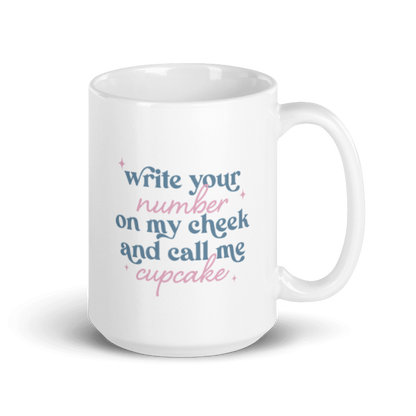 A white coffee mug with pink and blue text that reads "write your number on my cheek and call me cupcake"