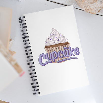 a spiral notebook with the cupcake logo on the cover. The cupcake logo is a large cupcake covered in sprinkles, with cupcake written over it in pink block letters