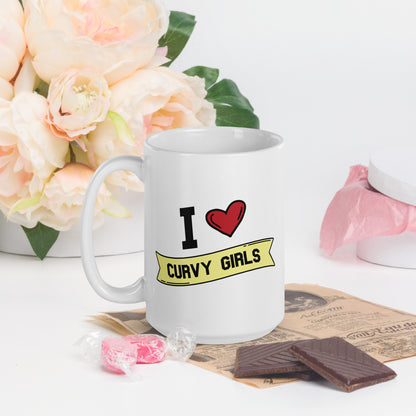 A white coffee mug that reads I Heart Curvy Girls,  with Curvy Girls in a yellow banner