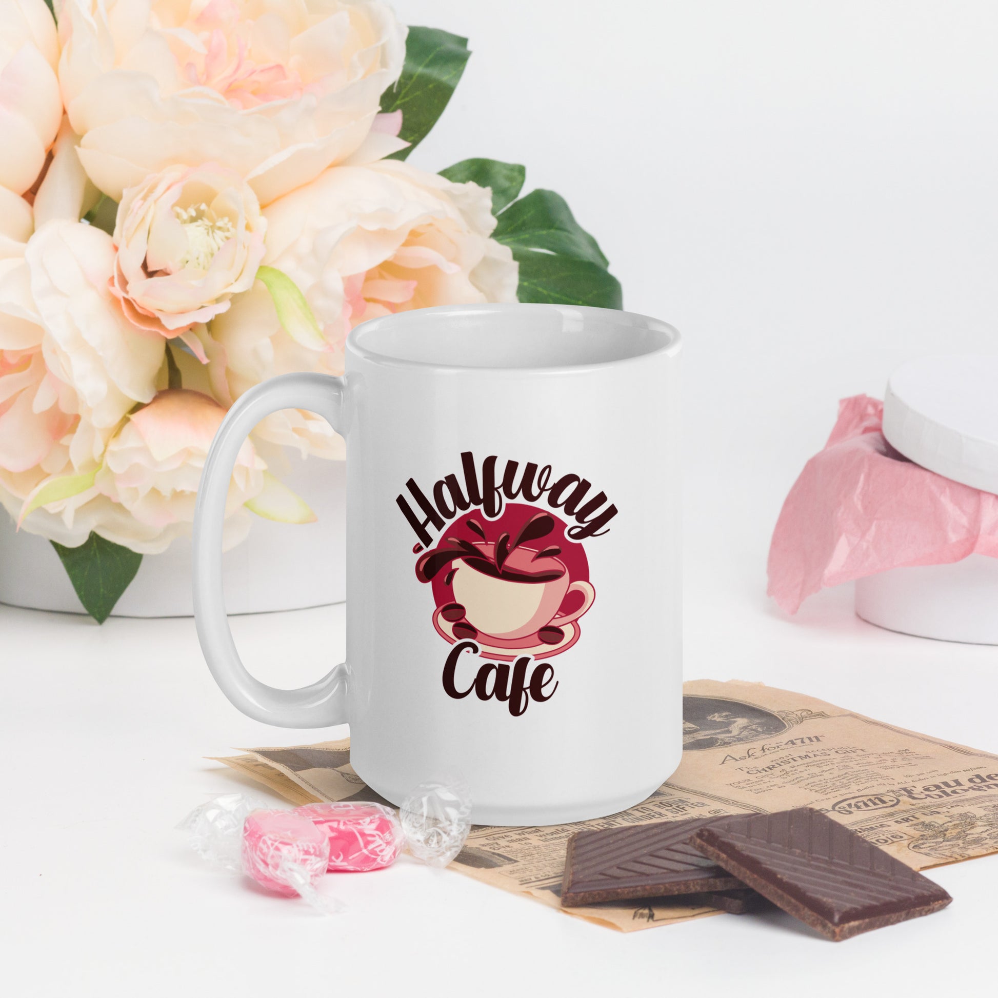A white mug with a large logo of a spilling cup of coffee, with the words Halfway Cafe written around it
