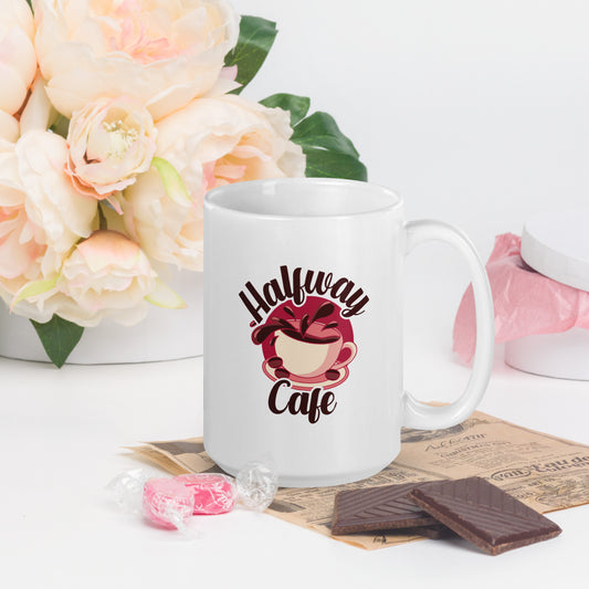 A white mug with a large logo of a spilling cup of coffee, with the words Halfway Cafe written around it