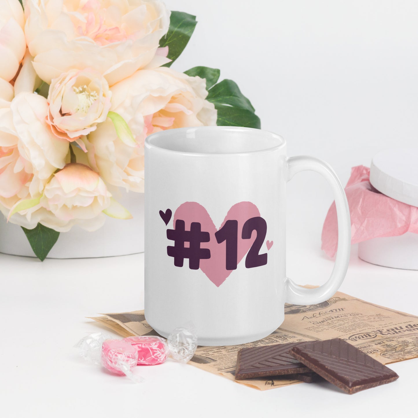 A white coffee mug with a logo of a heart under #12 in black text