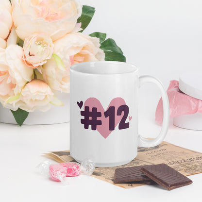 A white coffee mug with a logo of a heart under #12 in black text