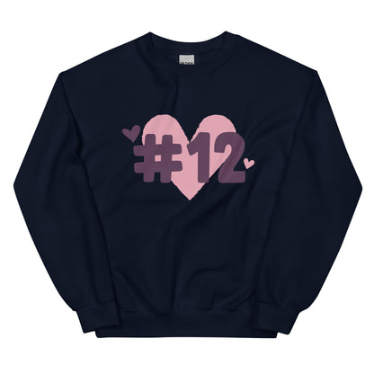 a navy crewneck sweatshirt with the I Heart #12 Logo. The Number 12 Logo is a large pink heart with #12 in black written over the heart.