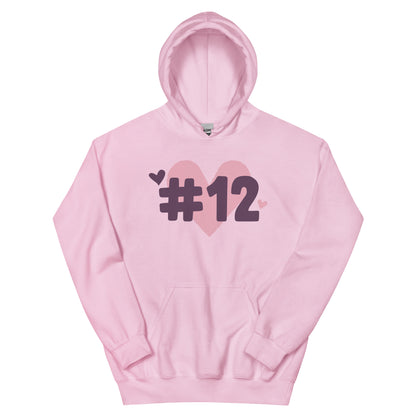 a pink hoodie with the I Heart #12 Logo. The Number 12 Logo is a large pink heart with #12 in black written over the heart.